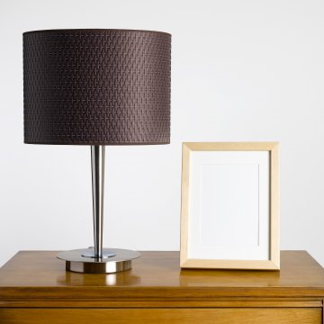 Digital picture frame on a desk by a lamp